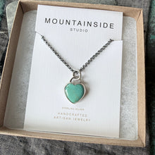 Necklace with a heart-shaped green pendant on a Mountainside Studio card.